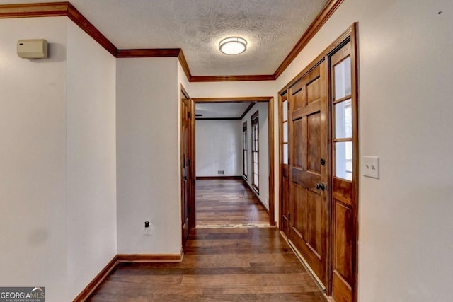 hallway featuring dark hardwood / wood-style flooring, ornamental molding, and a textured ceiling