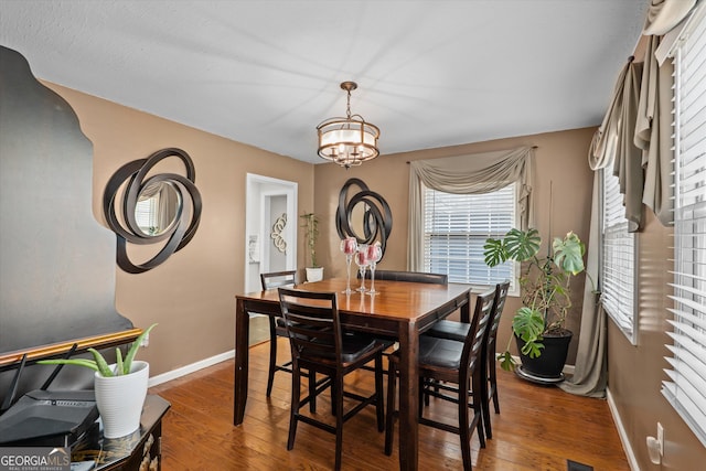 dining room with wood-type flooring and a notable chandelier