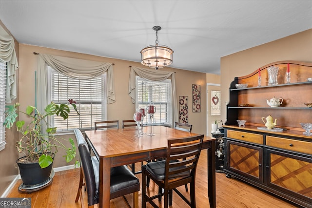 dining area with an inviting chandelier and light wood-type flooring