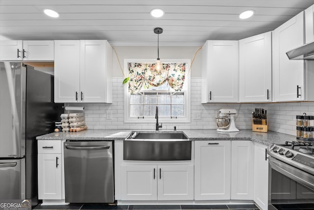 kitchen featuring pendant lighting, sink, appliances with stainless steel finishes, light stone countertops, and white cabinets