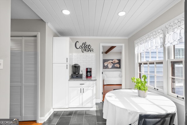 dining room featuring wood ceiling and ornamental molding