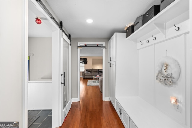 mudroom with dark wood-type flooring and a barn door