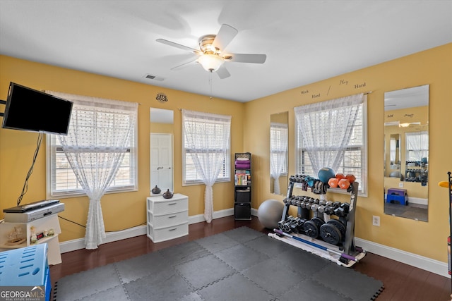 workout area with dark wood-type flooring and ceiling fan