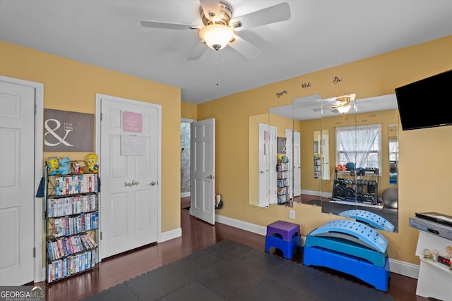 workout room featuring dark wood-type flooring and ceiling fan