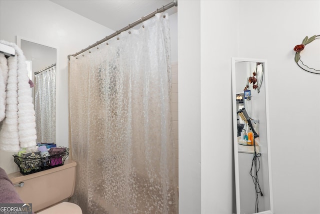 bathroom with a shower with curtain and toilet