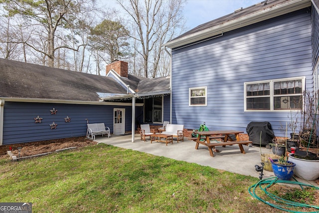 back of house with a lawn and a patio