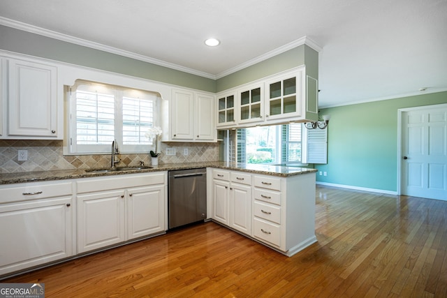 kitchen featuring stainless steel dishwasher, dark stone countertops, kitchen peninsula, and white cabinets