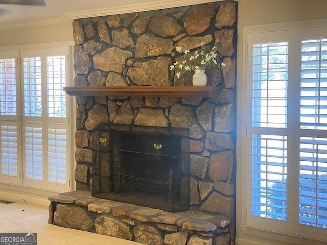 room details featuring crown molding, carpet, and a fireplace