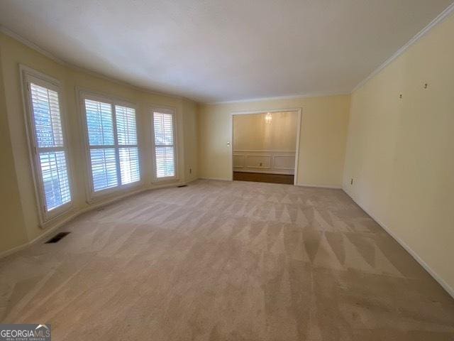 carpeted empty room featuring ornamental molding