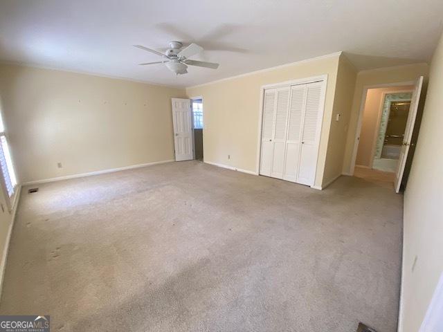 unfurnished bedroom featuring ceiling fan, carpet floors, and a closet