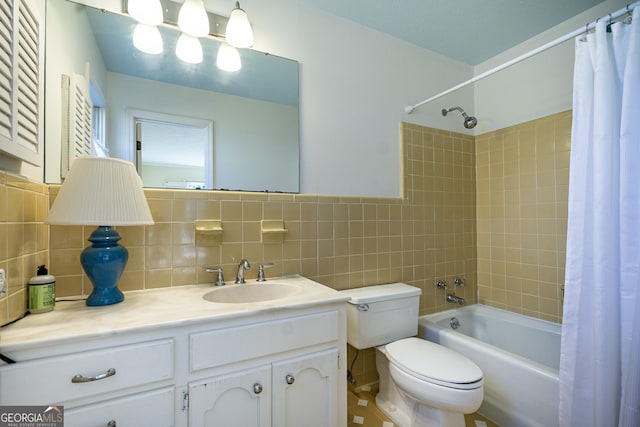 full bathroom with vanity, tile walls, shower / bath combo with shower curtain, and toilet