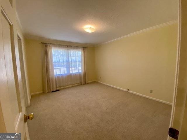 unfurnished room with crown molding and light colored carpet