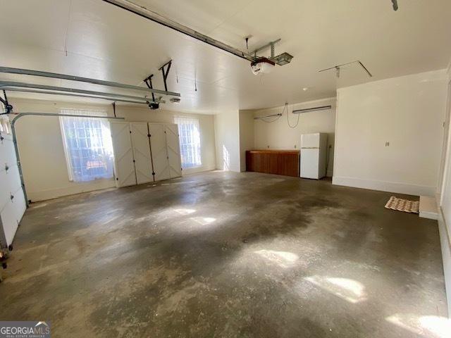 garage featuring a garage door opener and white fridge