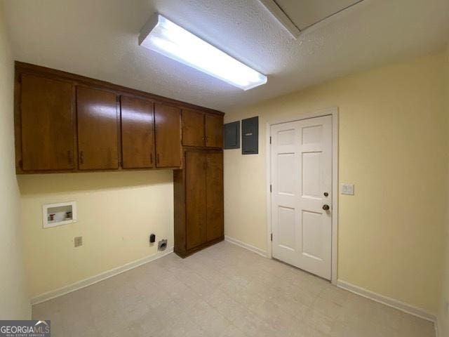 clothes washing area featuring cabinets, washer hookup, electric panel, and a textured ceiling