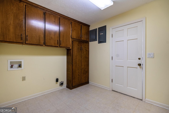 clothes washing area with cabinets, hookup for a washing machine, electric panel, and a textured ceiling