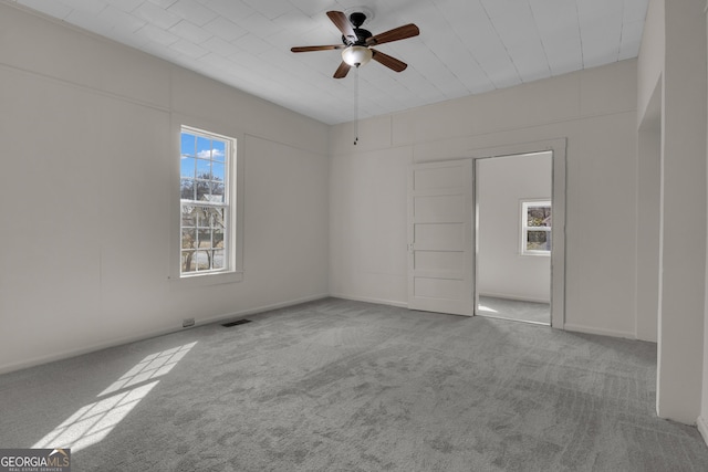 spare room featuring light colored carpet and ceiling fan