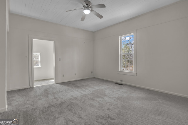 carpeted spare room with a wealth of natural light and ceiling fan