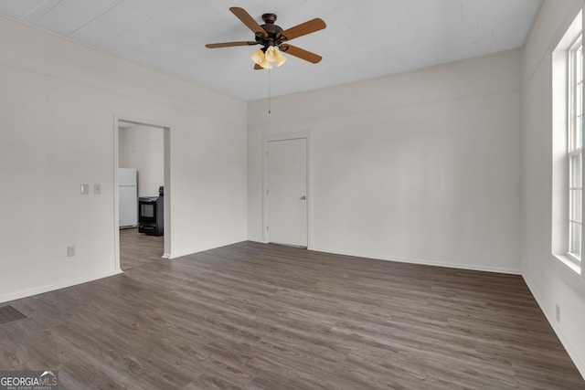 empty room featuring dark wood-type flooring and ceiling fan