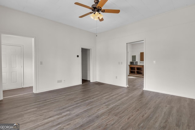 empty room featuring dark wood-type flooring and ceiling fan