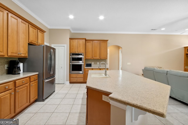 kitchen featuring stainless steel appliances, tasteful backsplash, sink, and a kitchen island with sink