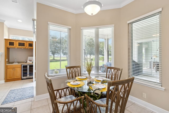 dining area featuring light tile patterned floors, crown molding, beverage cooler, and indoor wet bar