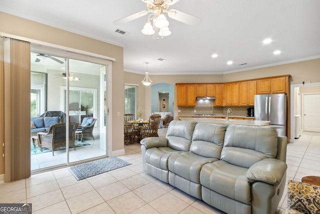 living room with light tile patterned floors, ornamental molding, sink, and ceiling fan