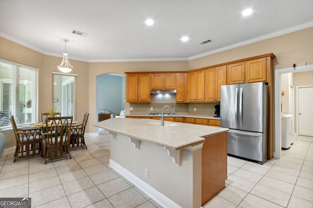 kitchen with light tile patterned floors, backsplash, a kitchen breakfast bar, stainless steel appliances, and an island with sink