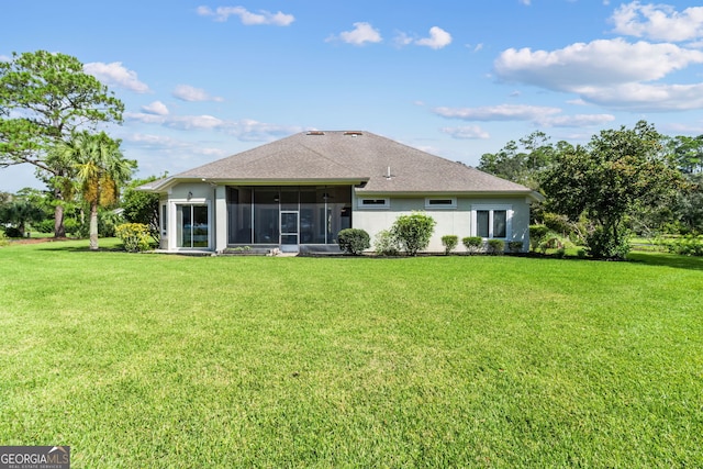 rear view of house featuring a yard and a sunroom