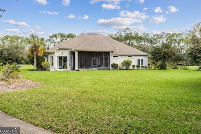 rear view of house with a yard and a sunroom