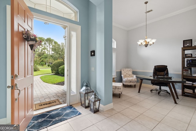 tiled entrance foyer featuring an inviting chandelier and ornamental molding