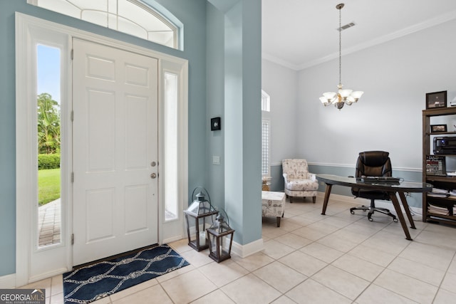 entrance foyer featuring crown molding, light tile patterned floors, and a chandelier