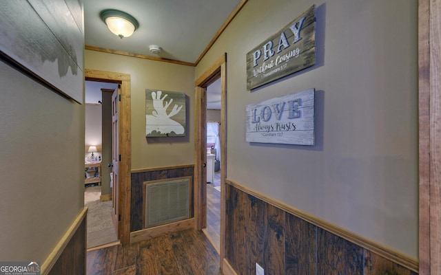 hall featuring ornamental molding, dark hardwood / wood-style flooring, and wood walls