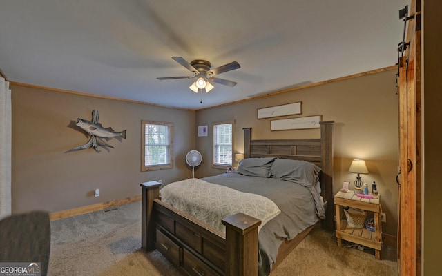 bedroom featuring crown molding, ceiling fan, a barn door, and carpet