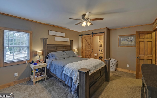 carpeted bedroom with ornamental molding, a barn door, and ceiling fan