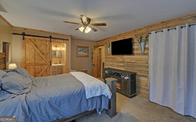 bedroom with wood walls, ornamental molding, carpet flooring, ceiling fan, and a barn door