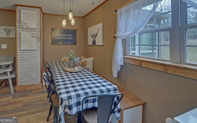 dining area with crown molding, a healthy amount of sunlight, and hardwood / wood-style flooring