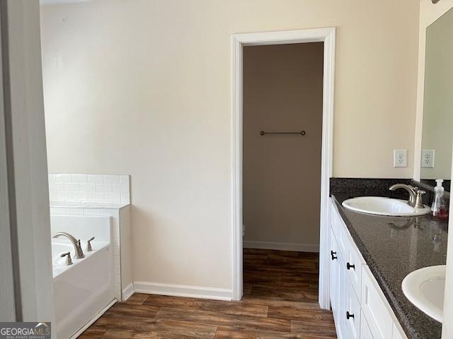 bathroom with vanity, hardwood / wood-style floors, and a washtub