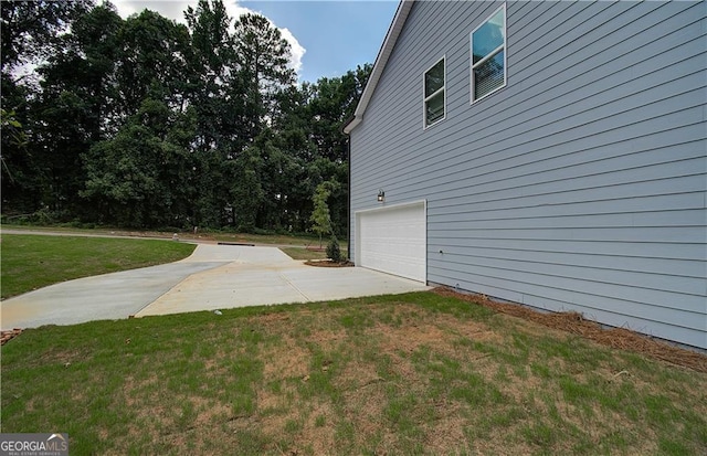 view of side of home with a garage and a lawn