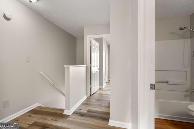 corridor featuring hardwood / wood-style flooring and a textured ceiling