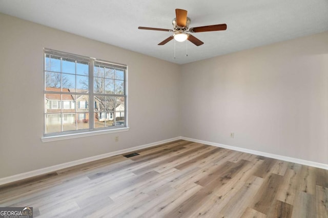 spare room with ceiling fan and light wood-type flooring