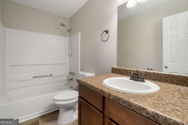 full bathroom featuring hardwood / wood-style flooring, vanity, bathtub / shower combination, and toilet