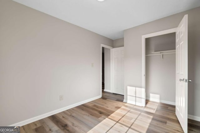 unfurnished bedroom with light hardwood / wood-style floors and a closet