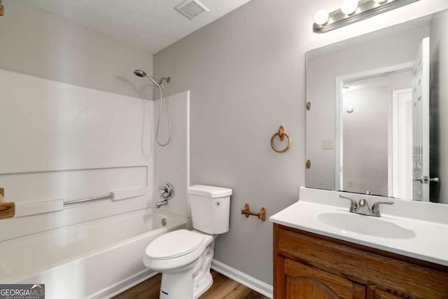 full bathroom featuring hardwood / wood-style floors, shower / bathing tub combination, vanity, toilet, and a textured ceiling