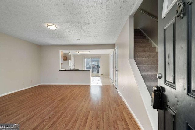 foyer with a textured ceiling and light hardwood / wood-style floors