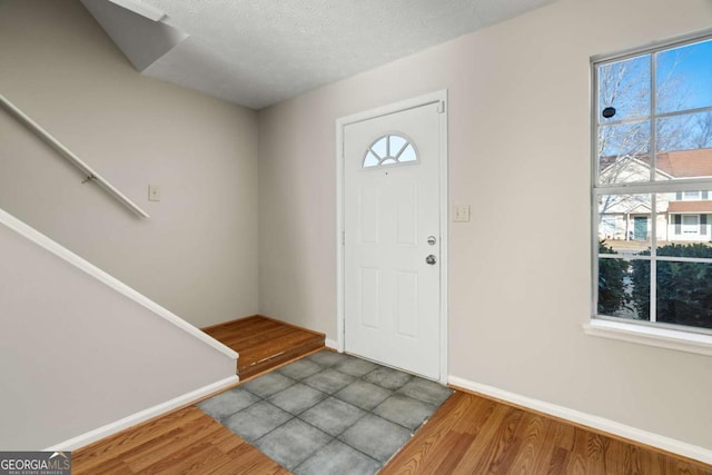 foyer entrance with wood-type flooring and a textured ceiling