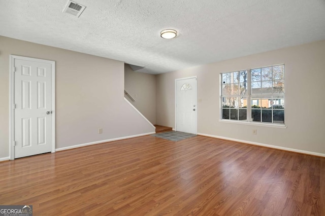 entryway with wood-type flooring and a textured ceiling