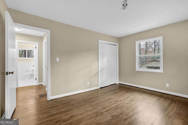 unfurnished bedroom featuring dark hardwood / wood-style flooring and a closet