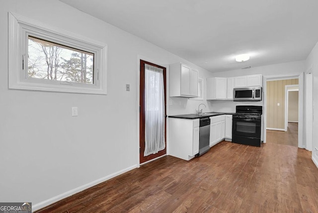 kitchen featuring white cabinetry, sink, dark hardwood / wood-style flooring, and appliances with stainless steel finishes