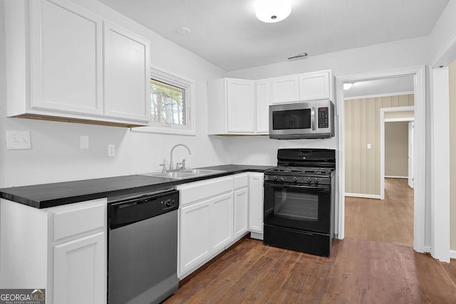 kitchen with white cabinetry, stainless steel appliances, dark hardwood / wood-style flooring, and sink