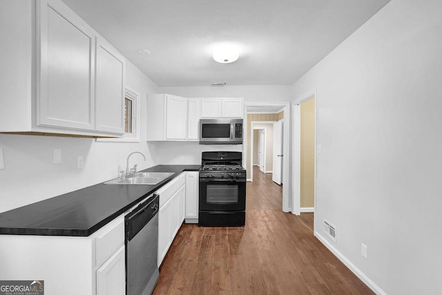 kitchen featuring stainless steel appliances, white cabinetry, sink, and dark wood-type flooring